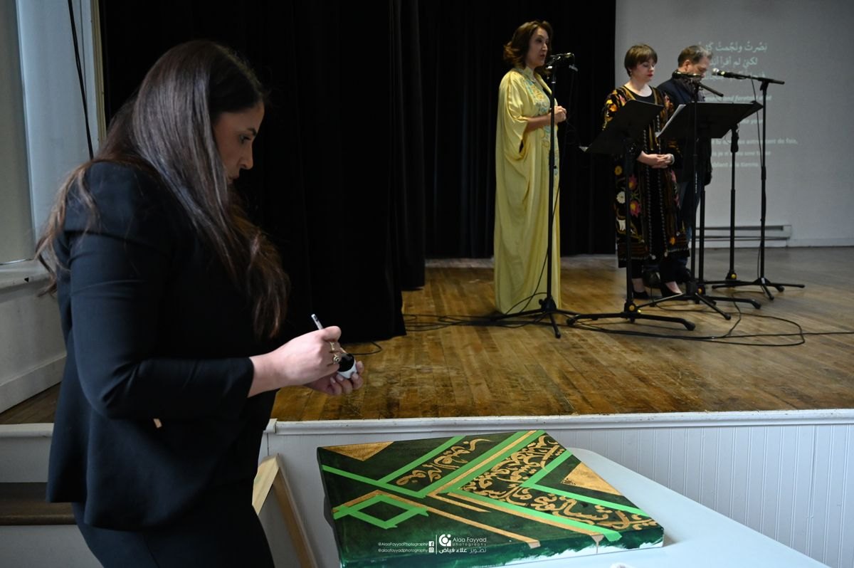 Hala Ali preparing to paint live during a stage performance