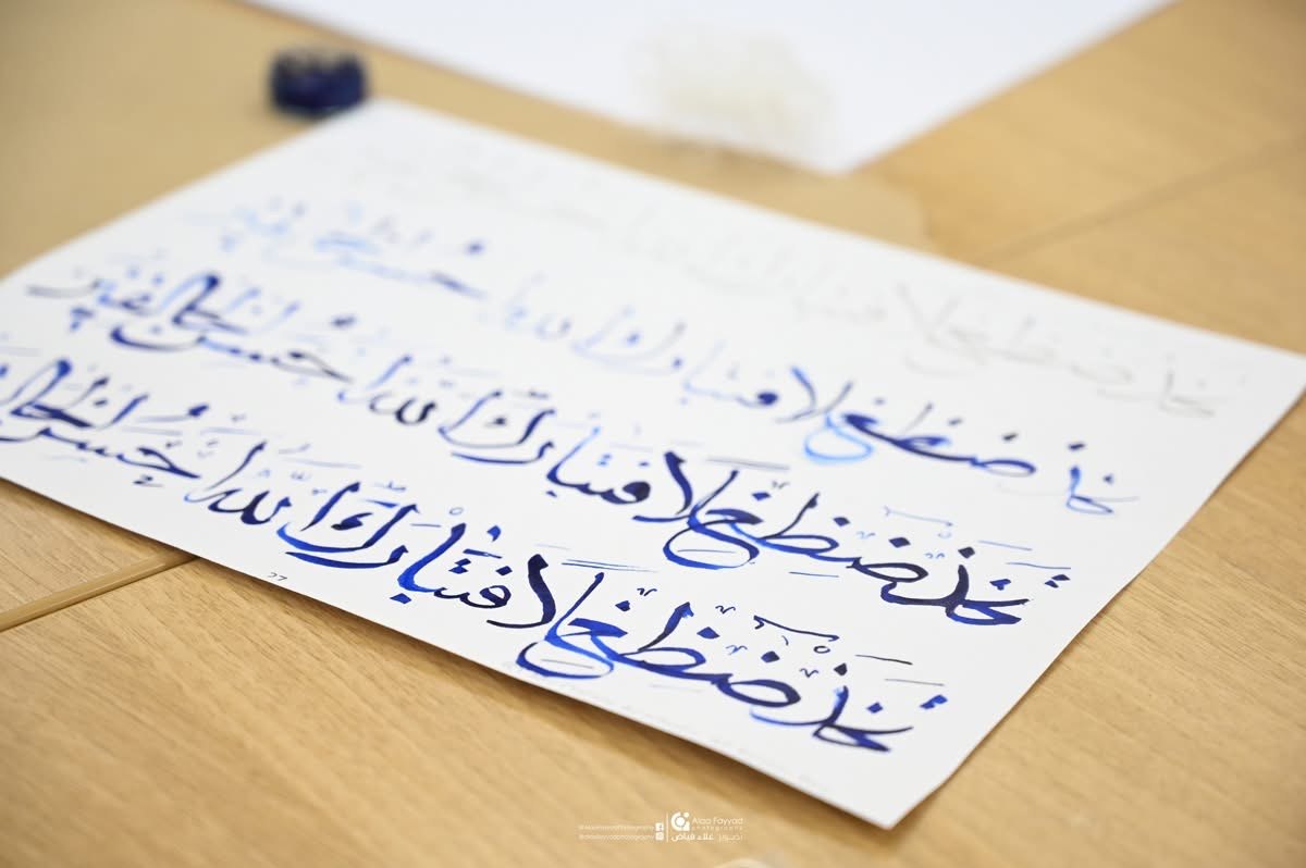 Blue calligraphy practice on paper from a Hala Ali workshop