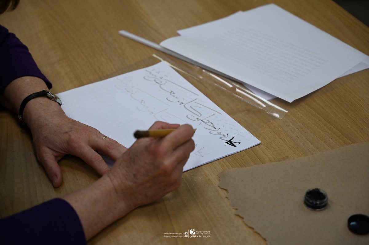 Workshop participant hand-lettering Arabic calligraphy