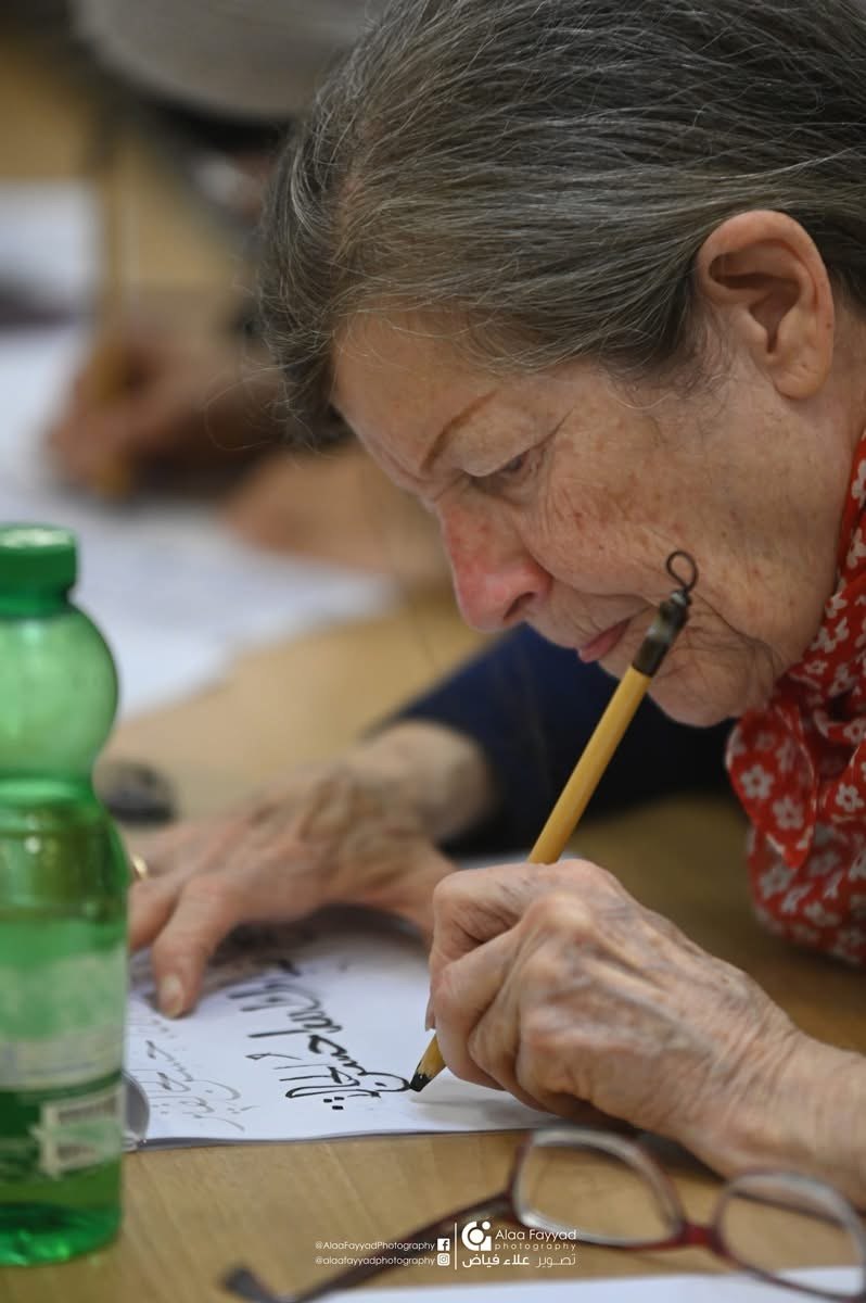 Student practicing Arabic calligraphy at a Hala Ali workshop